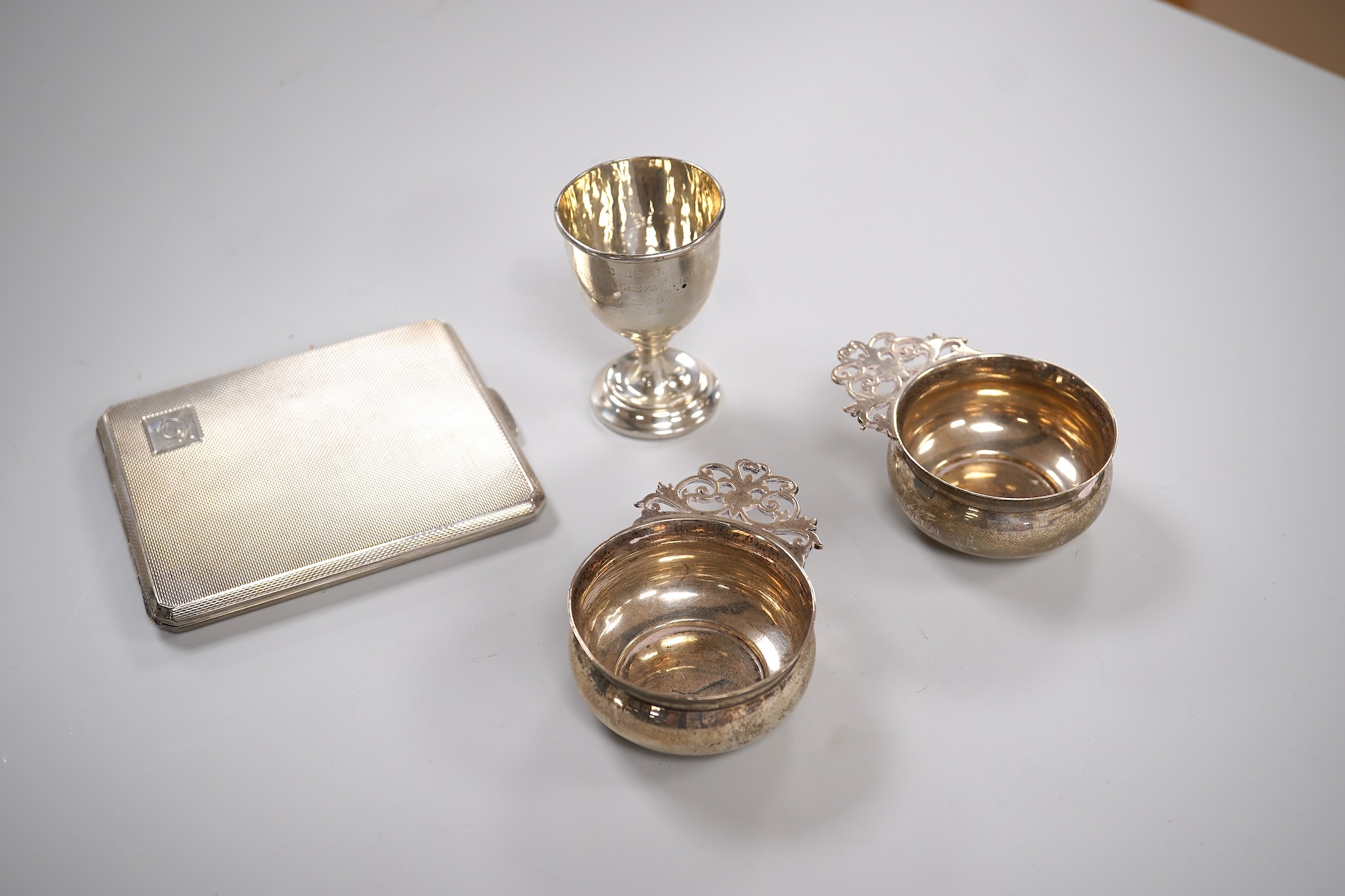 A George V engine turned silver cigarette case by Smith & Bartlam, Birmingham, 1921, a pair of Edwardian silver single handled small dishes by Goldsmiths & Silversmiths Co Ltd and a silver egg cup.